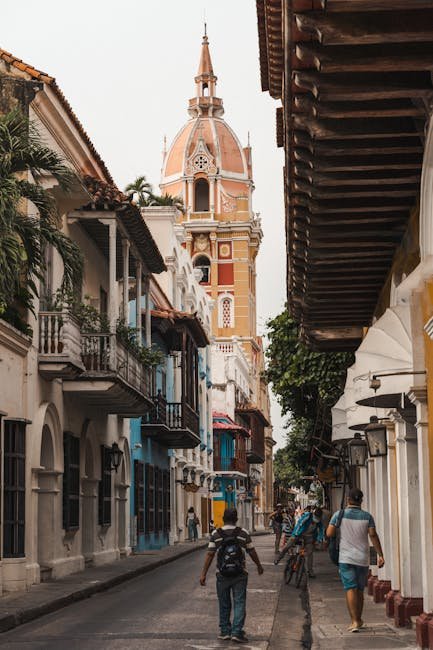 LEGAL ACTIVE Scenic street scene in Cartagena featuring the iconic cathedral tower.